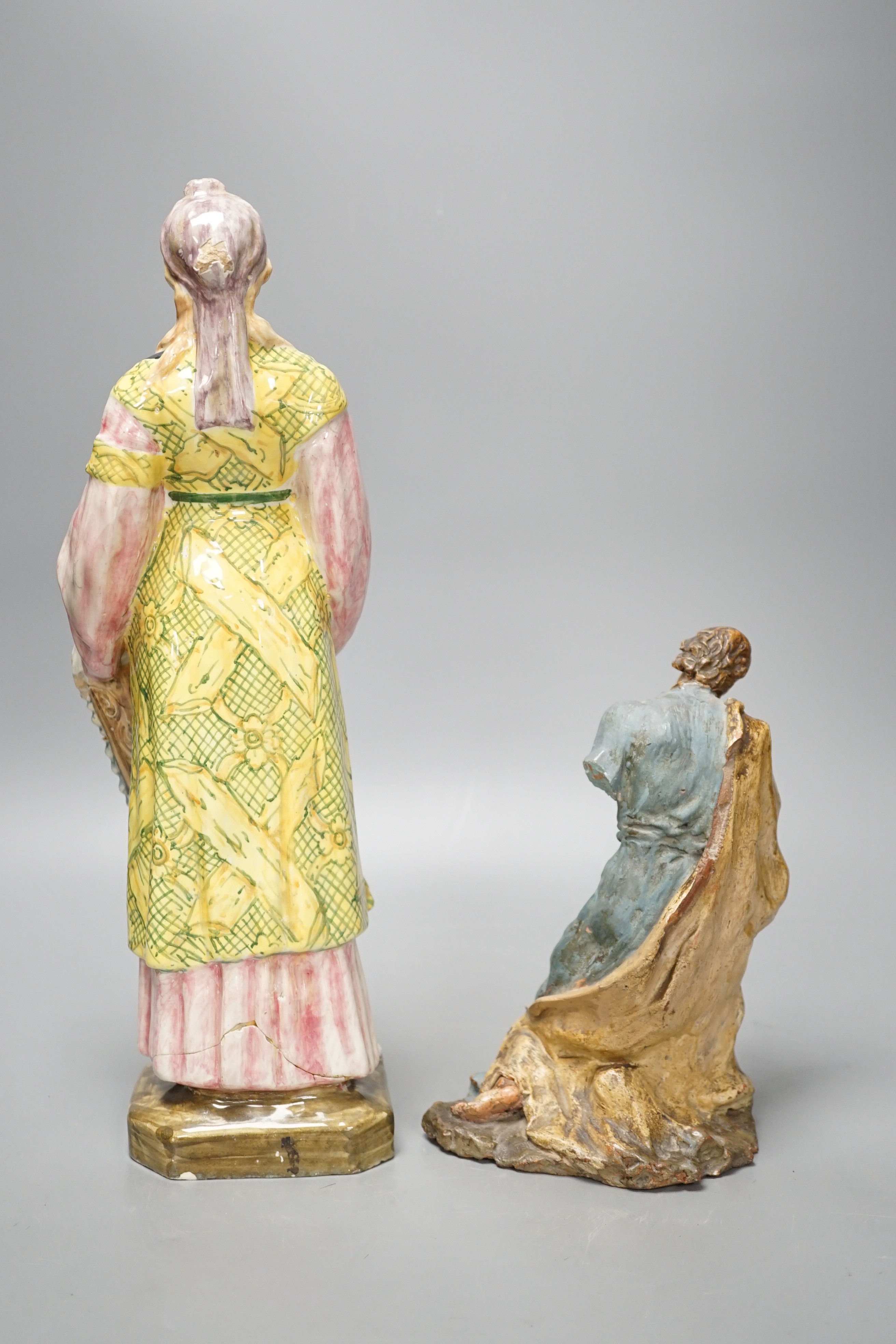 A late 19th century Italian maiolica figure of a Grecian woman or goddess with pipes and Sicilian terracotta figure of a Saint, tallest 38cm